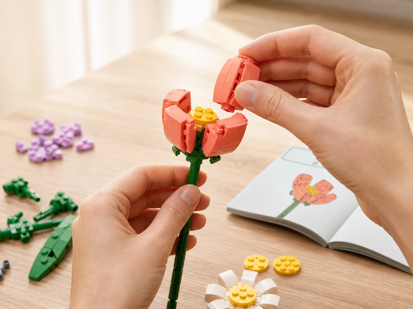 Mains assemblant les pétales en briques d’une fleur corail